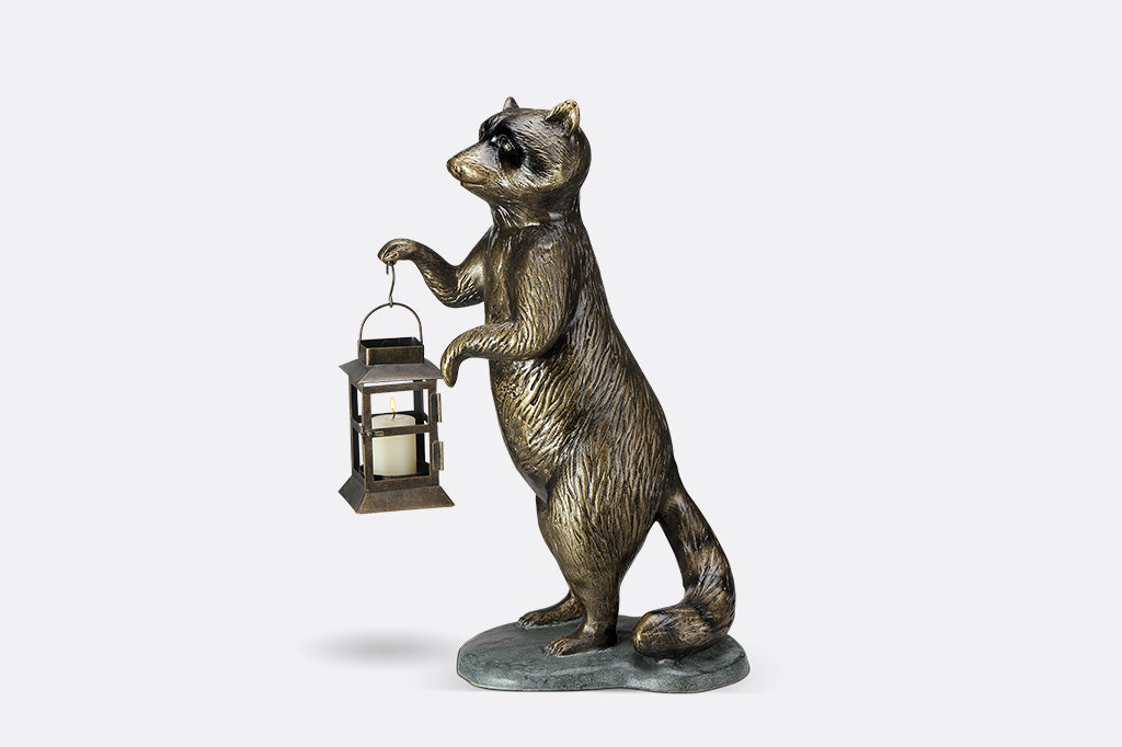 Sculpture of a raccoon holding a lantern on a white background