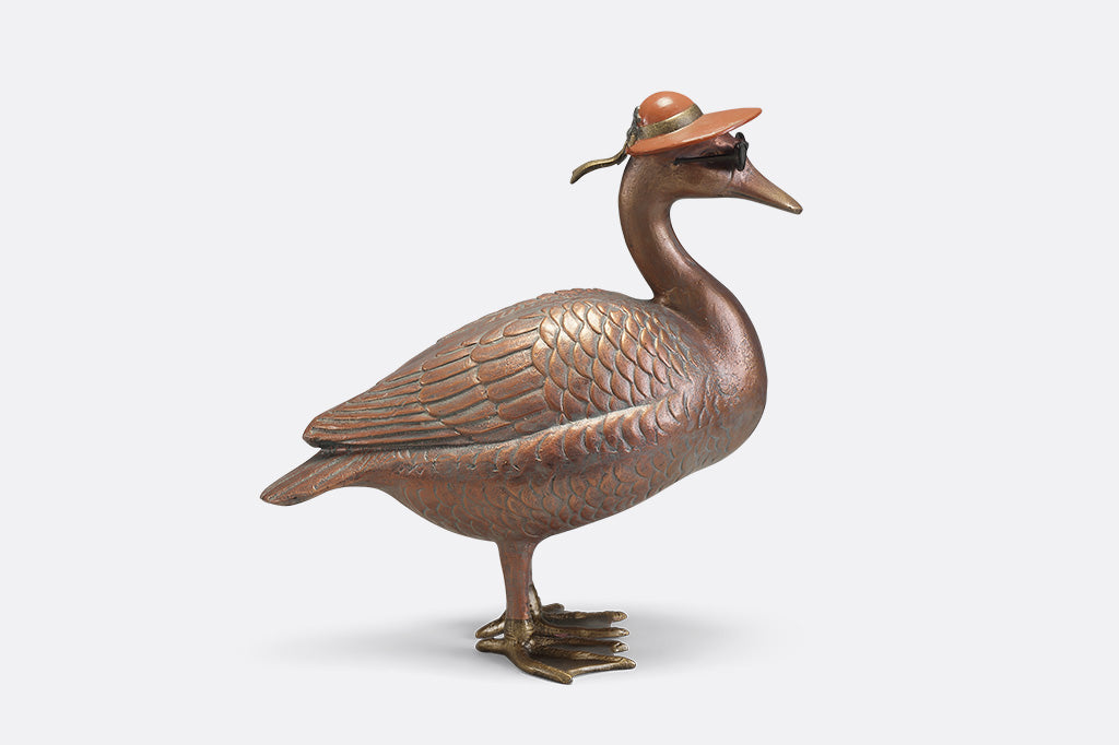 A sculpture of a duck wearing sunglasses and a sunhat.