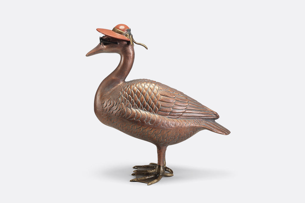 A sculpture of a duck wearing sunglasses and a sunhat.