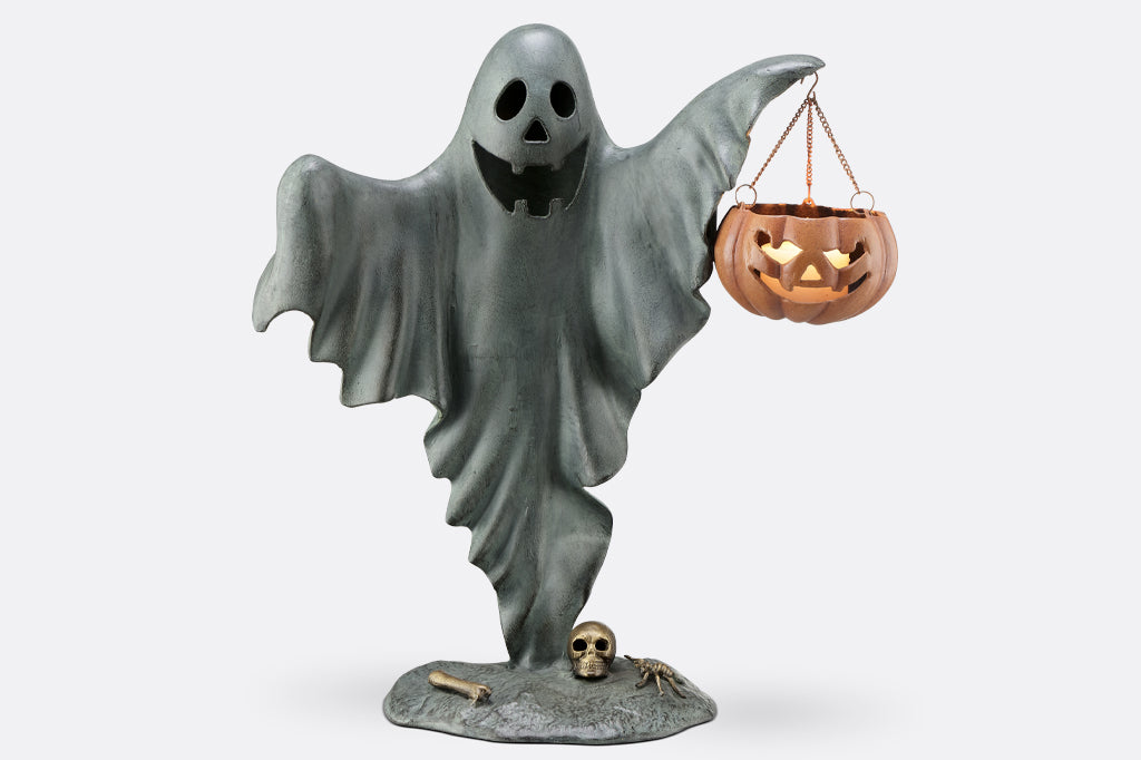 cast metal smiling ghost holding jack o lantern with candle inside 