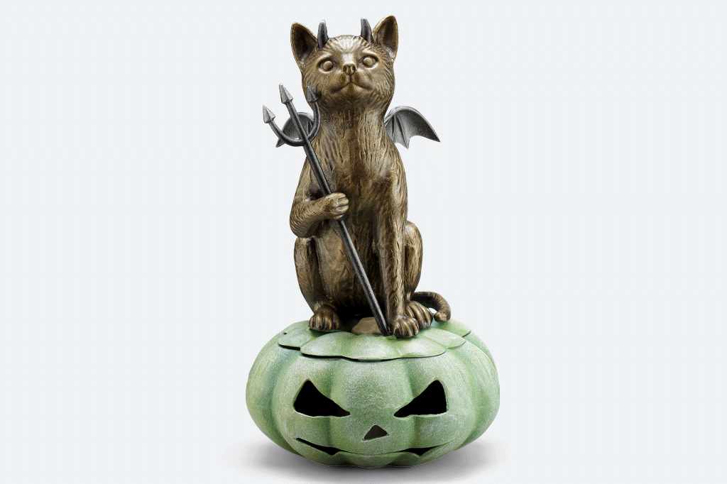 animation of cast metal devil cat with wings sat on green jack o lantern 