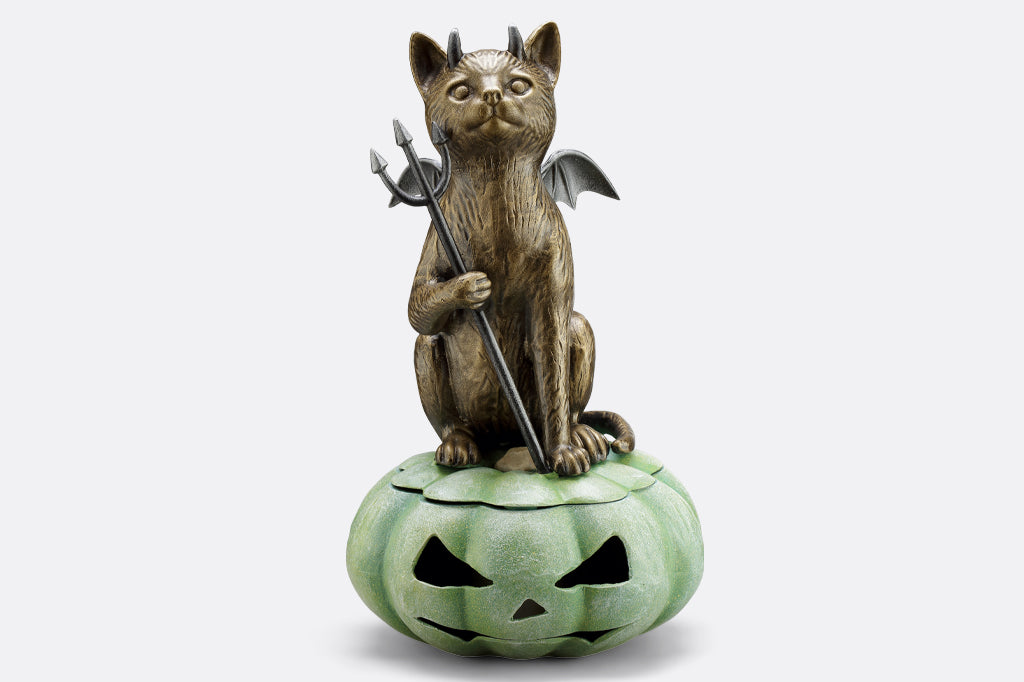 cast metal devil cat on green jack o lantern 