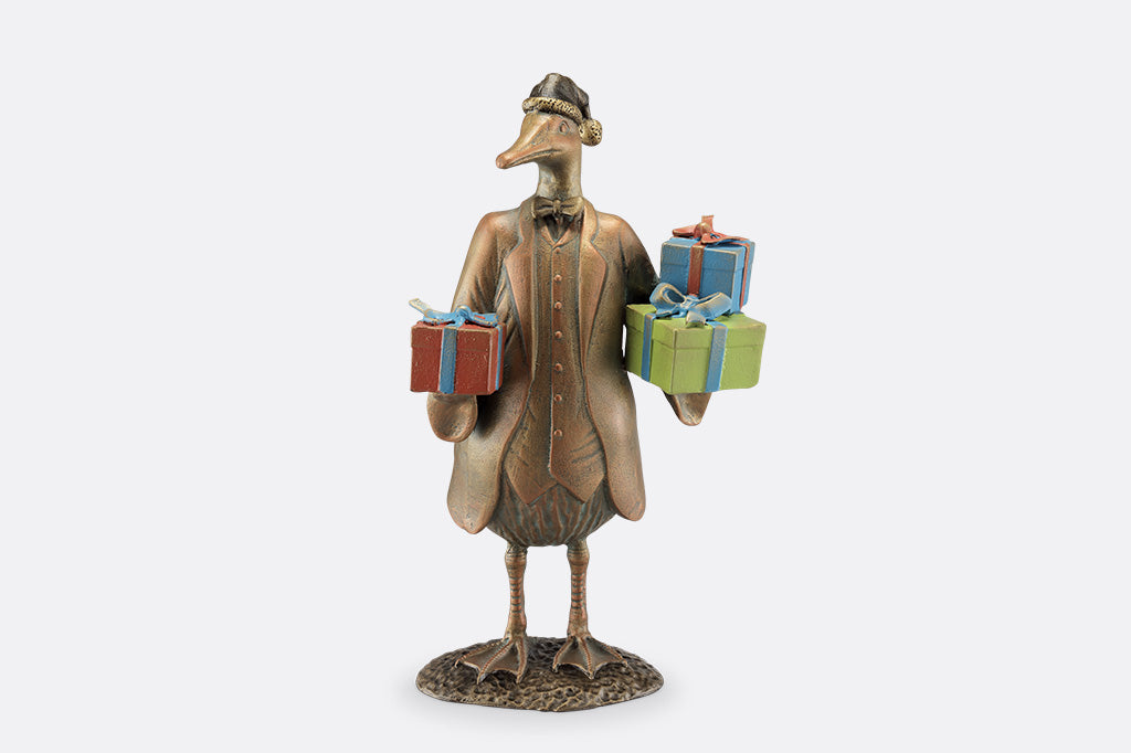 Decorative figurine of a bird holding gift boxes on a white background