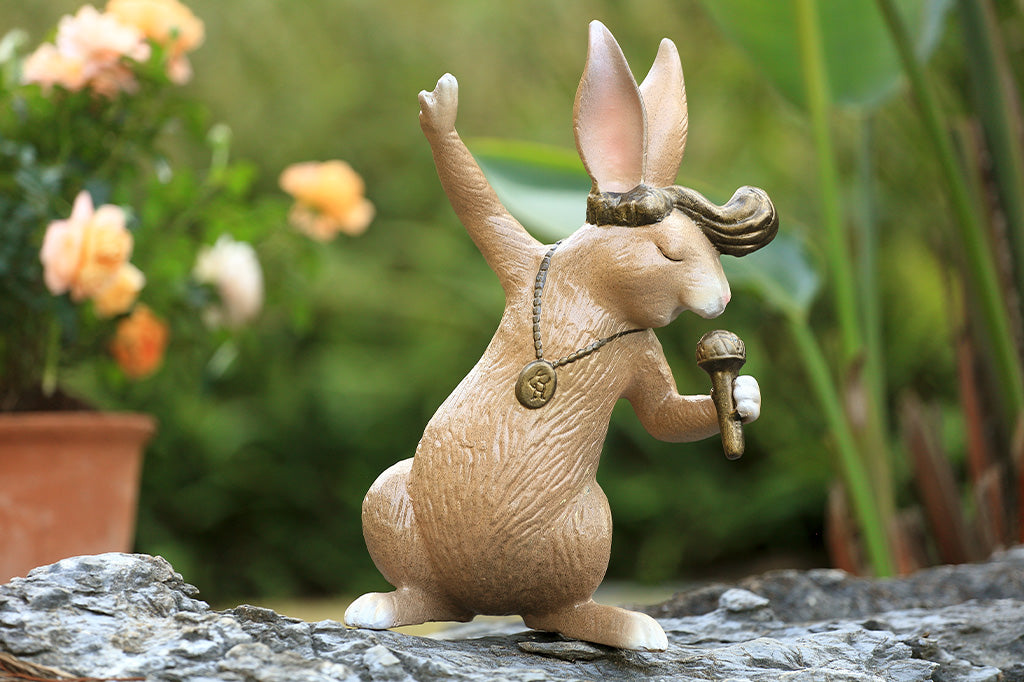 A sculpture of a rabbit with swept up hair, necklace, and a microphone.
