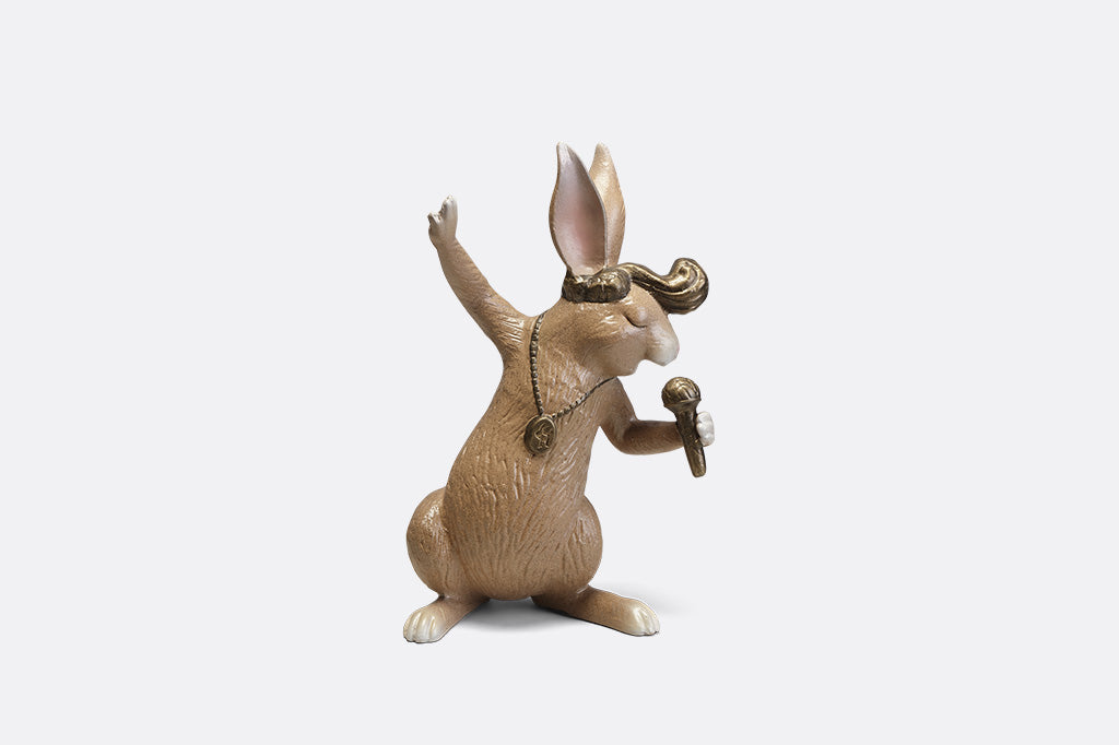 A sculpture of a rabbit with swept up hair, necklace, and a microphone.