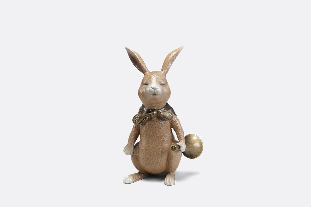 A sculpture of a bunny with a scarf and horn.