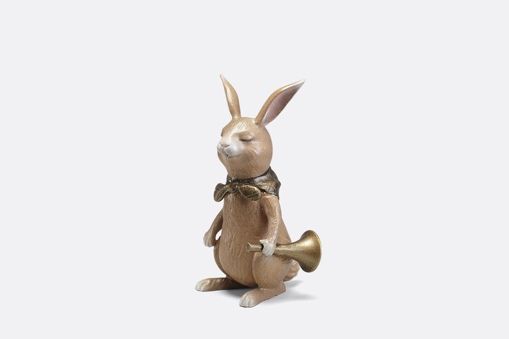 A sculpture of a bunny with a scarf and horn.