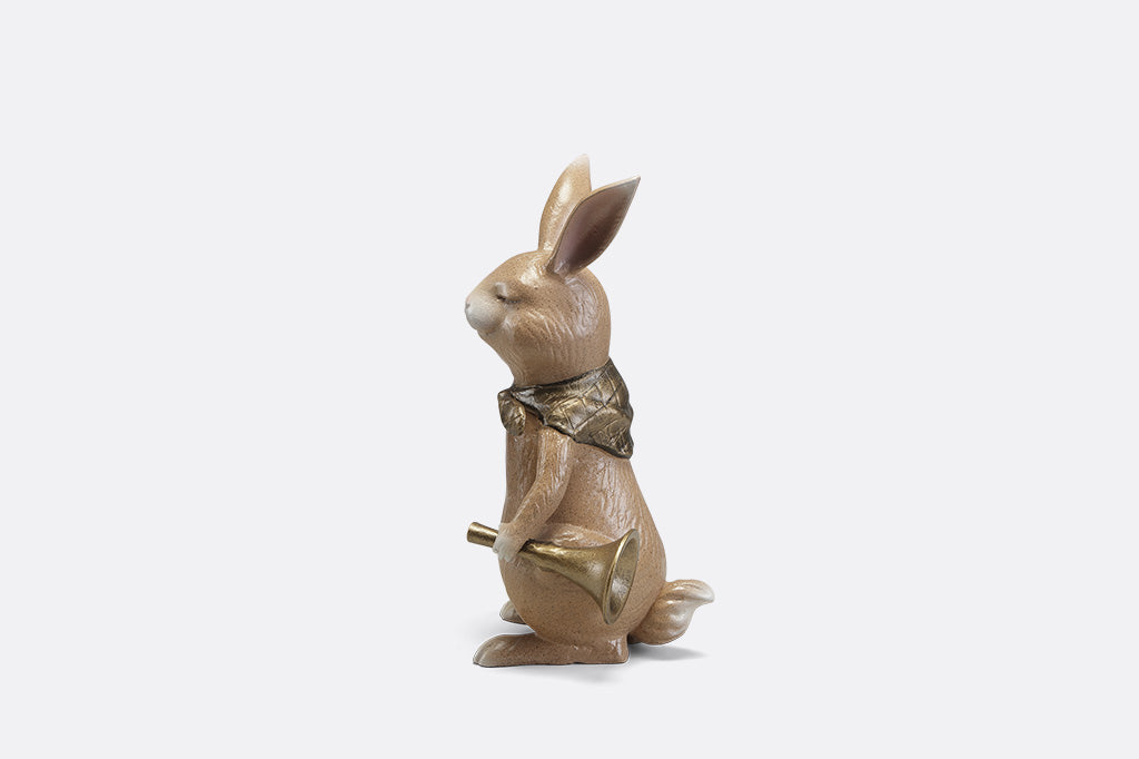 A sculpture of a bunny with a scarf and horn.