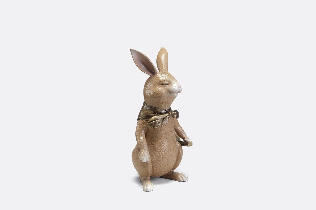 A sculpture of a bunny with a scarf and horn.