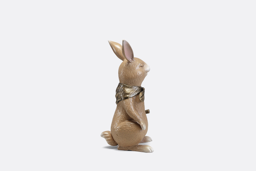 A sculpture of a bunny with a scarf and horn.