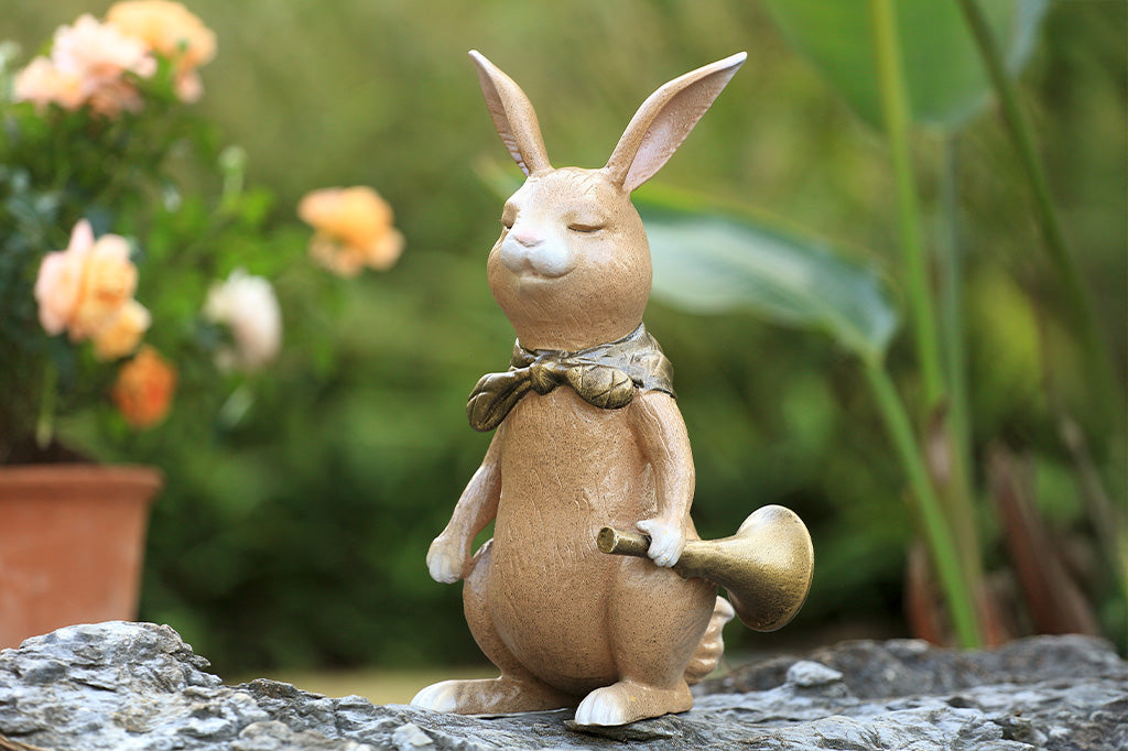 A sculpture of a bunny with a scarf and horn.