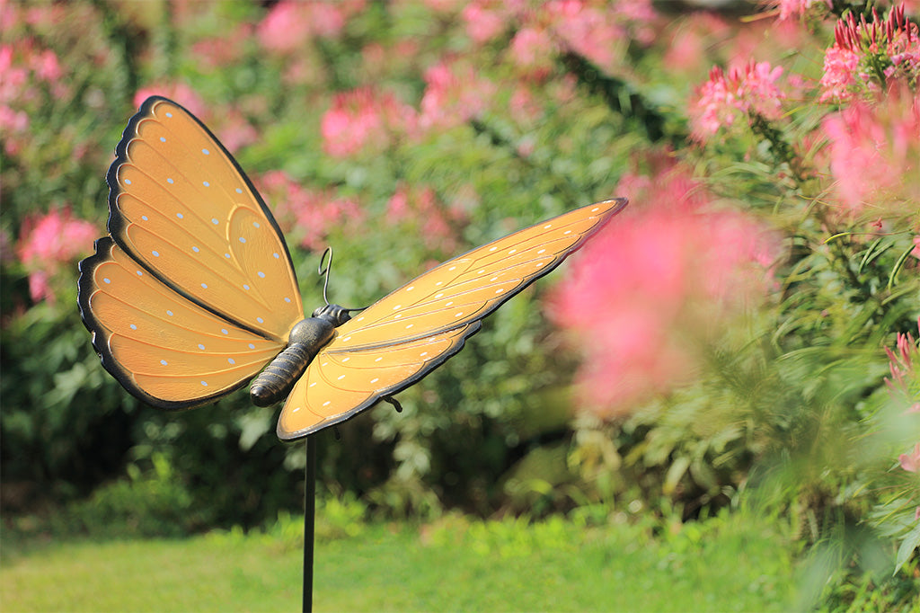 Butterfly-shaped garden ornament with a blurred floral background