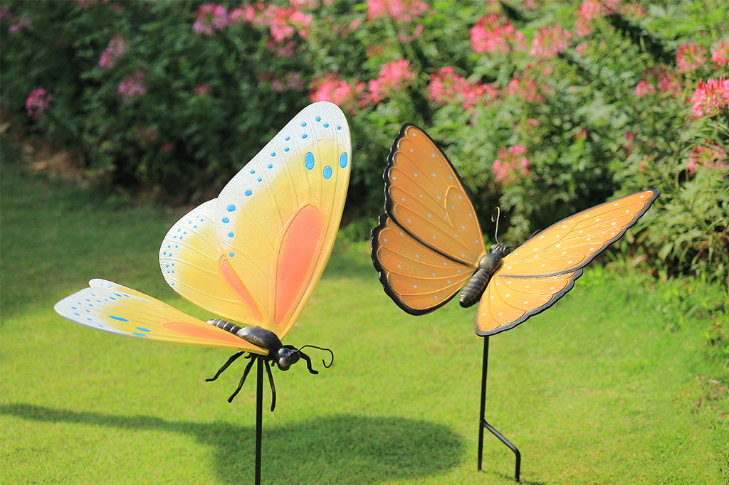 Two colorful butterfly garden stakes n a garden