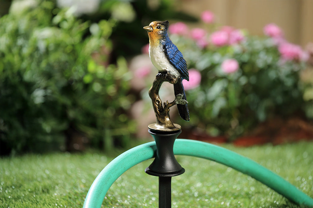 A hose guard sculpture of a Blue Bird sitting upon a twig.