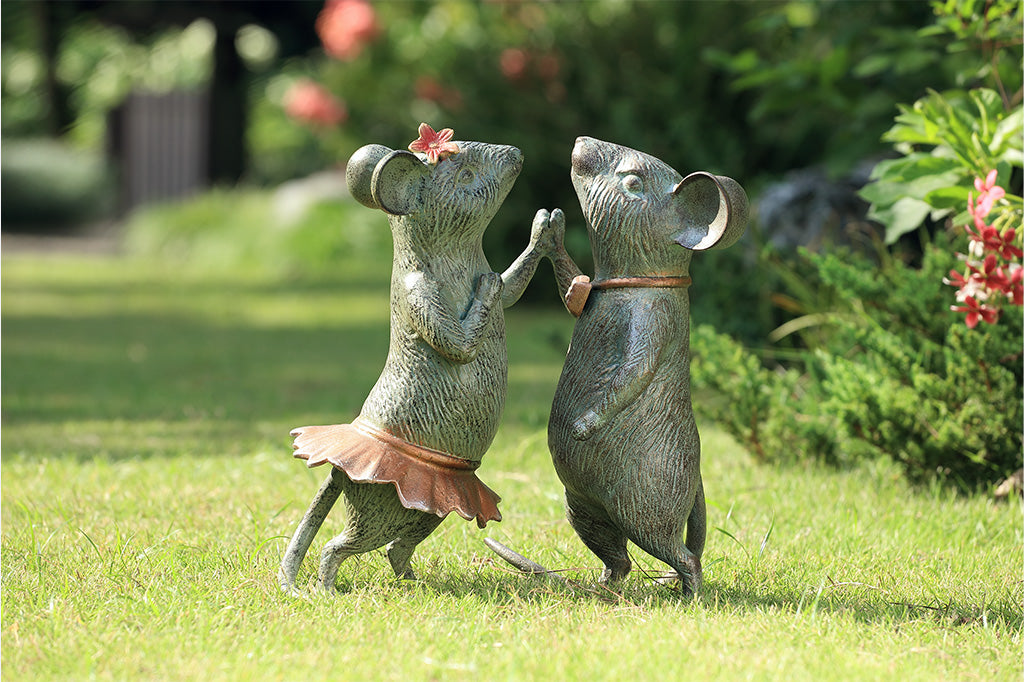 A statue of two mice holding hands and dancing