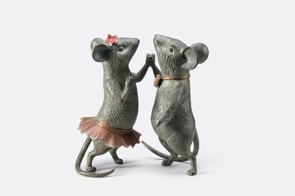 A statue of two mice holding hands and dancing