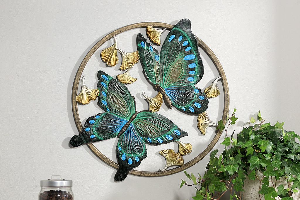 Circular wall art piece with ginkgo flowers and two blue and green butterflies.