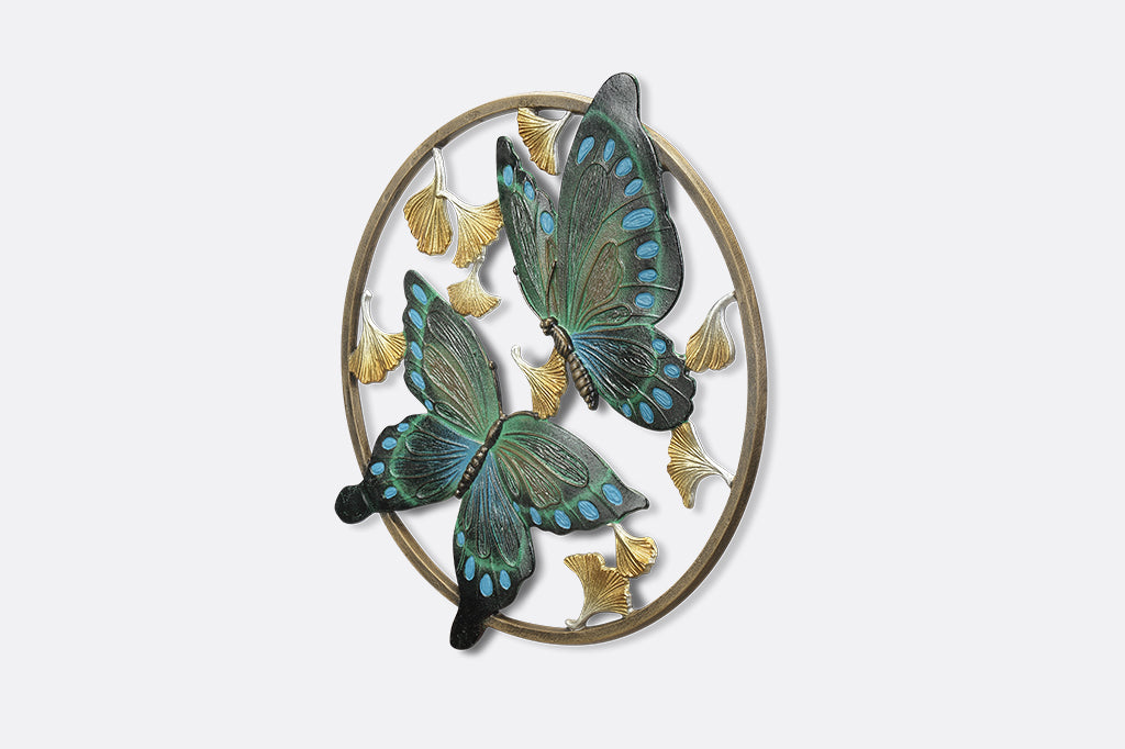 Circular wall art piece with ginkgo flowers and two blue and green butterflies.