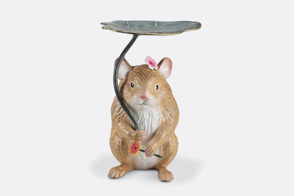 A sculpture of a hamster holding a leaf and flower