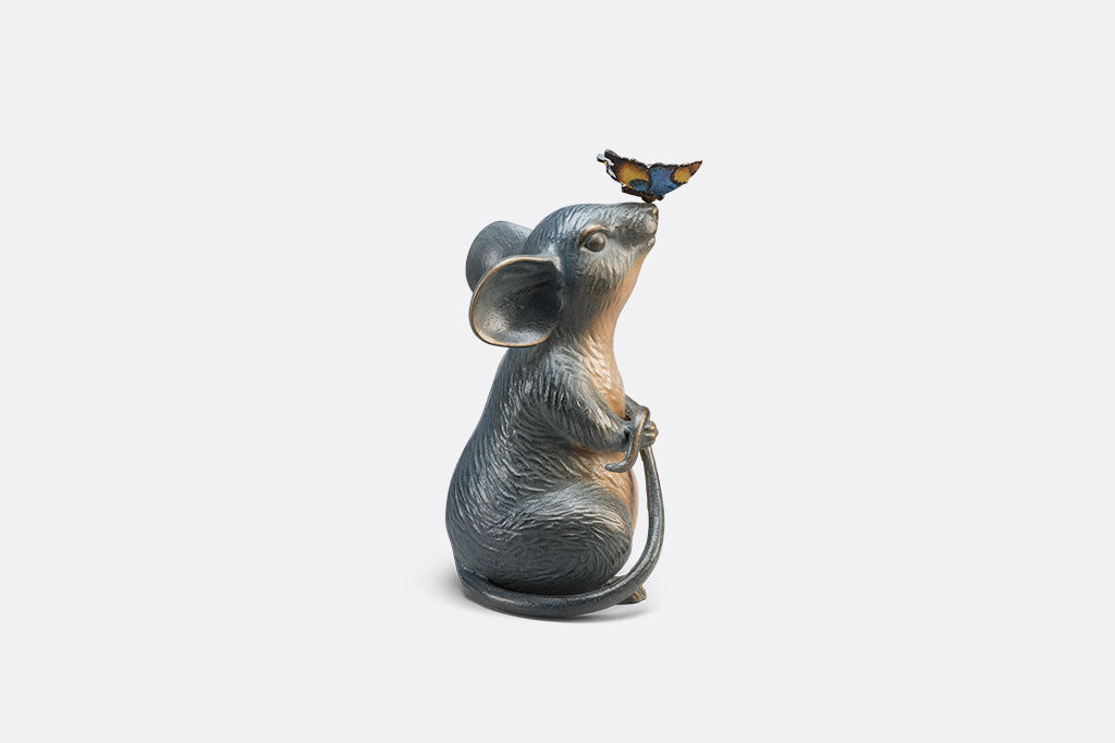 Statue of a mouse with a butterfly on its nose on white background