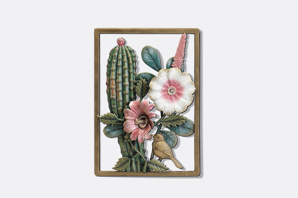 A decorative wall art of a desert scene with cacti, flowers, and birds.