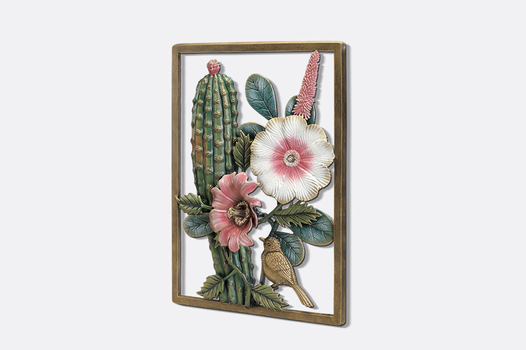 A decorative wall art of a desert scene with cacti, flowers, and birds.