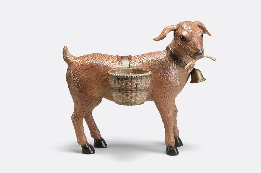 A planter sculpture of a goat with a bell carrying two baskets at his side.