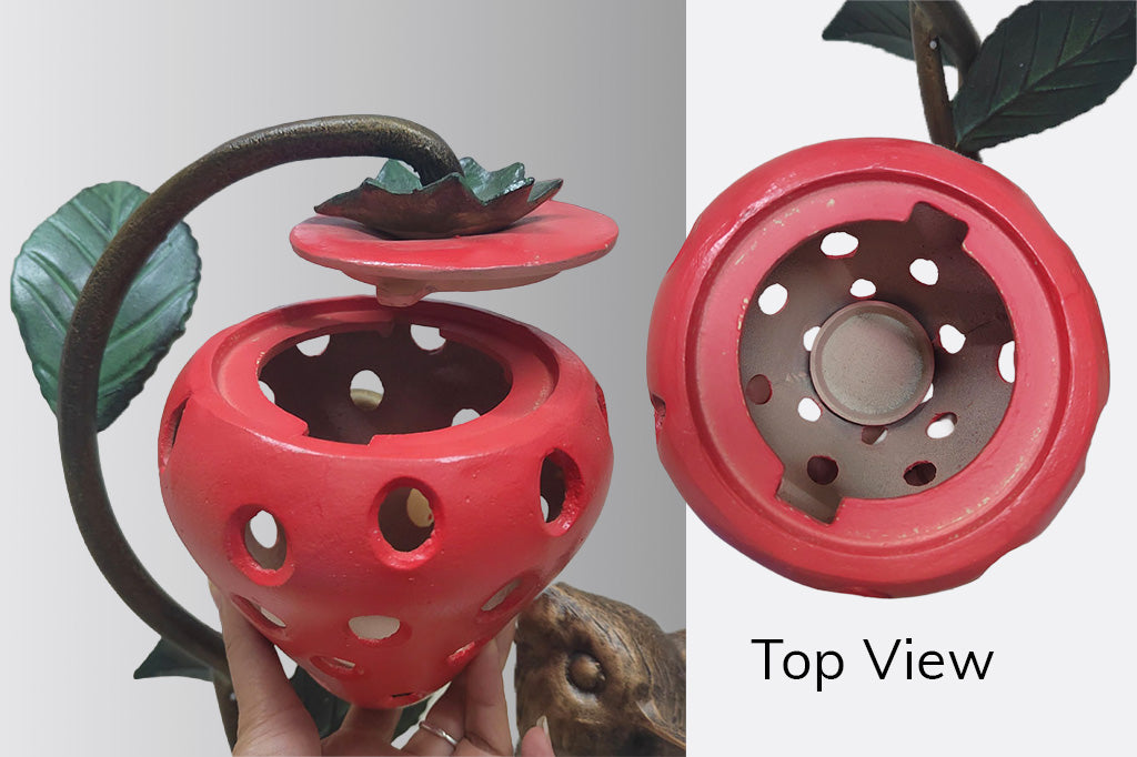 Red  strawberry-theme candle lantern with a top view showing its interior candle access point and lid design.