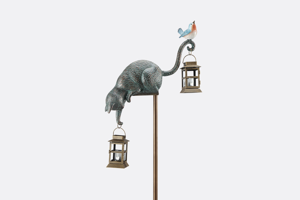 Decorative garden stake with cat and bird design on a white background