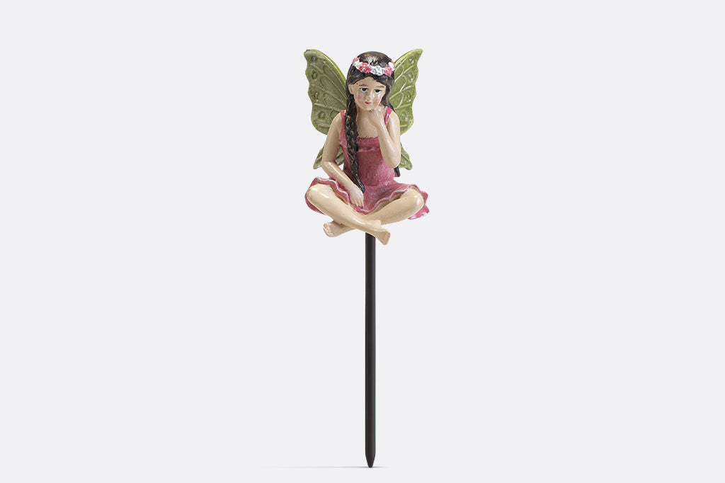 A plant pot stake sculpture of a fairy wearing pink.