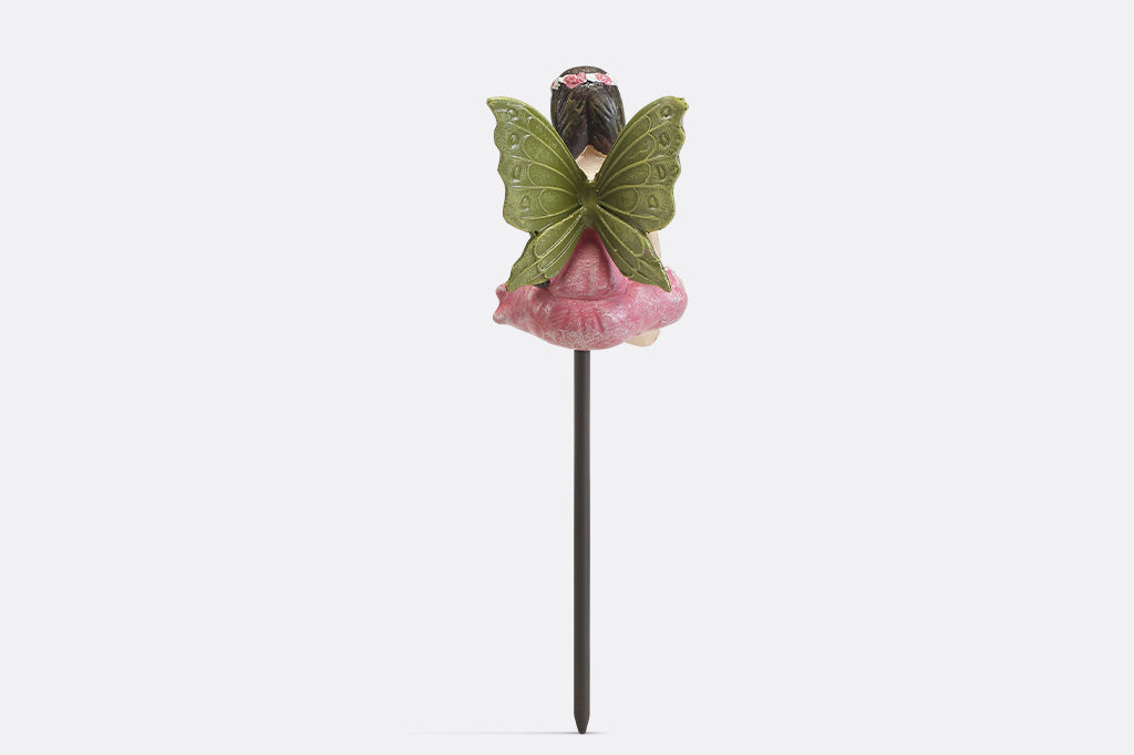 A plant pot stake sculpture of a fairy wearing pink.