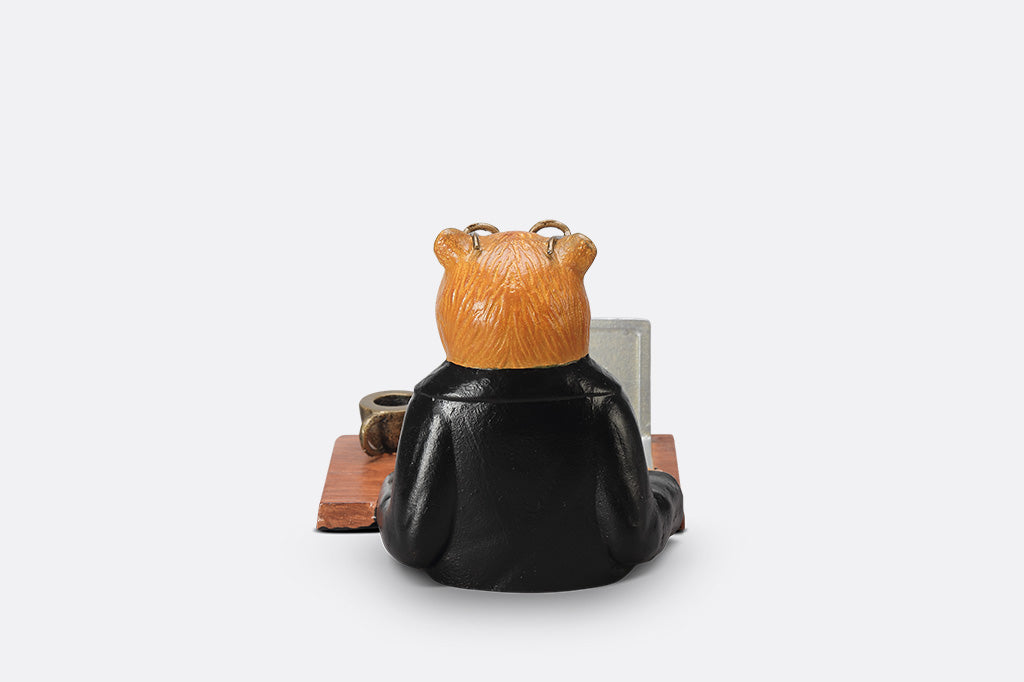 A sculpture of a bear wearing a suit on his Fishbook Pro laptop with a mug.