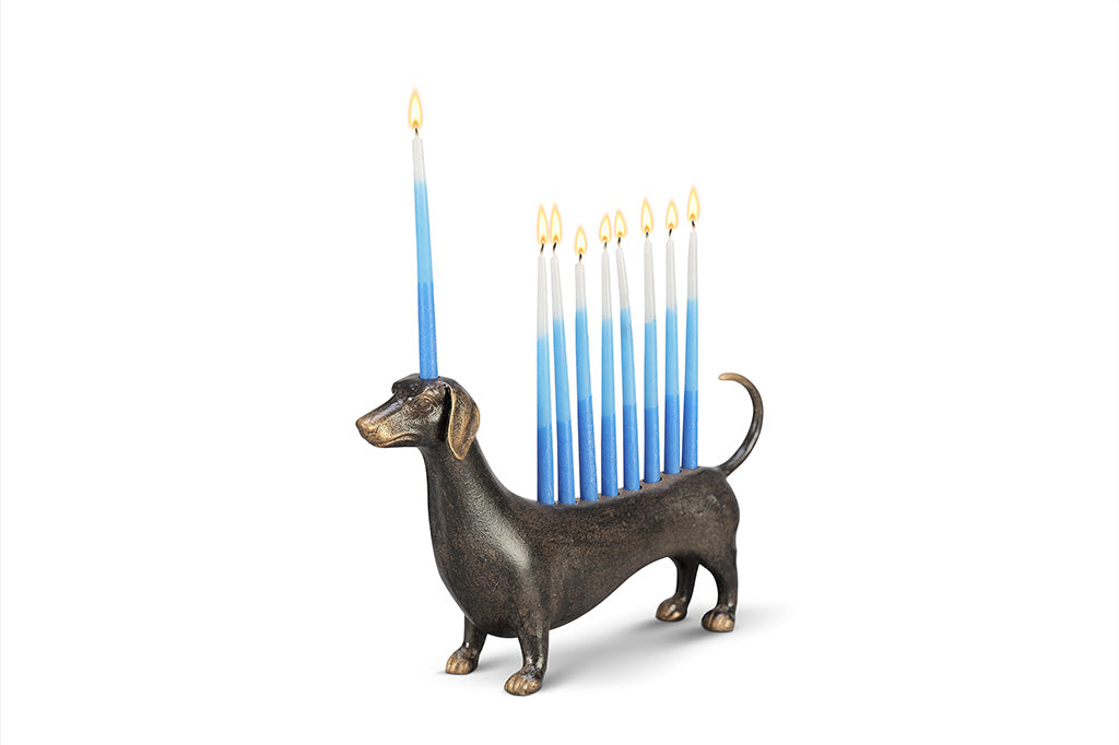 A dachshund-shaped Hanukkah menorah holding nine blue lit candles.