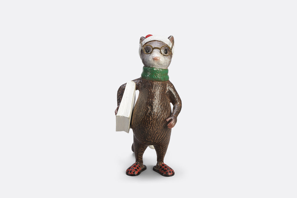 A mouse with glasses, a long night cap, slippers, a green scarf, and a book called "The Art of Dozing."