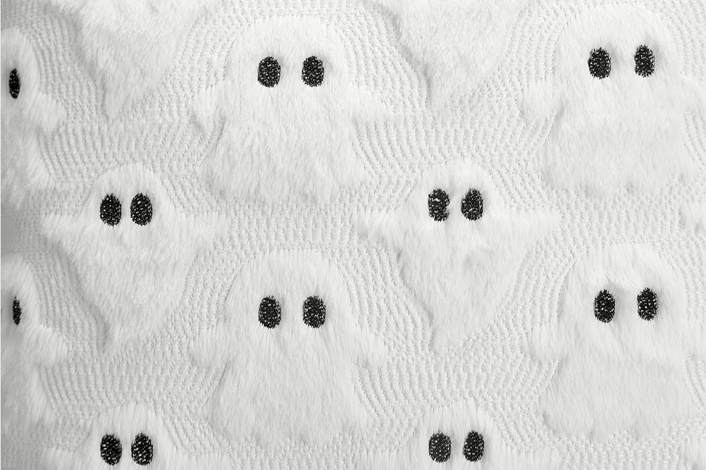 Close-up of textured white fabric with black specks on a white background