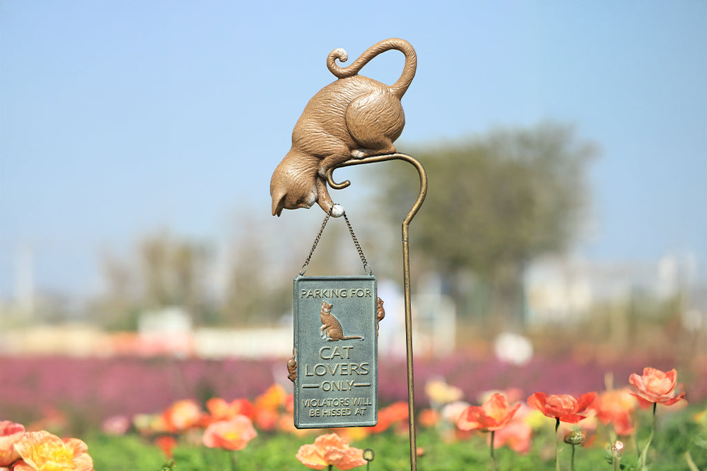 Staked sculpture sign of a cat holding a sign with mice that says "Parking for cat lovers only. Violators will be hissed at."