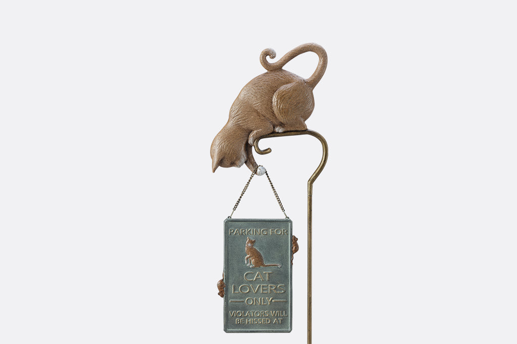 Staked sculpture sign of a cat holding a sign with mice that says "Parking for cat lovers only. Violators will be hissed at."