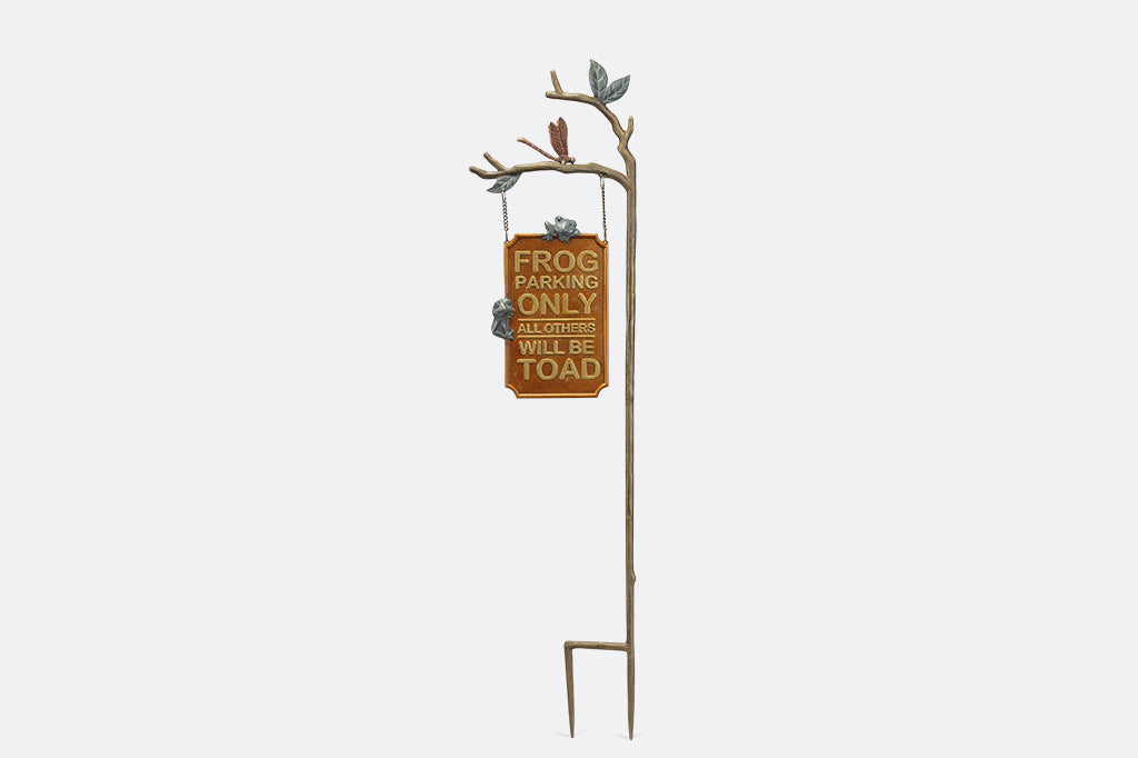 A staked sign with frogs, dragonflies, and branches, with a sign that reads "Frog Parking Only. All others will be toad."