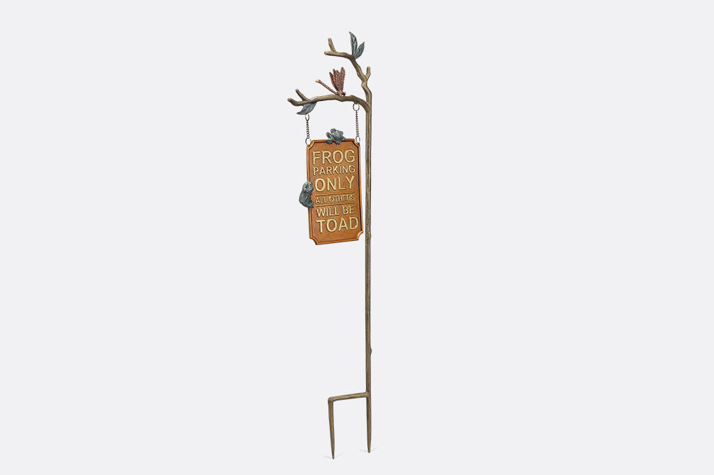 A staked sign with frogs, dragonflies, and branches, with a sign that reads "Frog Parking Only. All others will be toad."