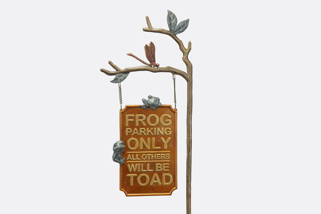 A staked sign with frogs, dragonflies, and branches, with a sign that reads "Frog Parking Only. All others will be toad."