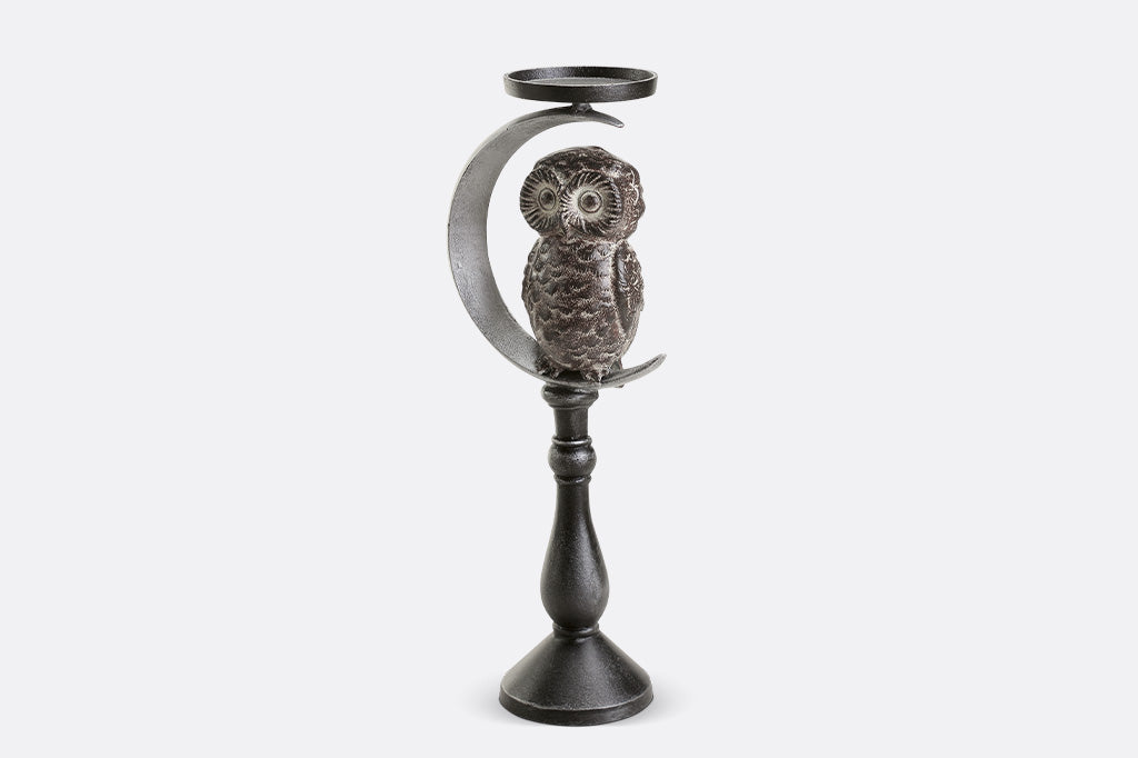 Decorative candle holder with owl design on a white background
