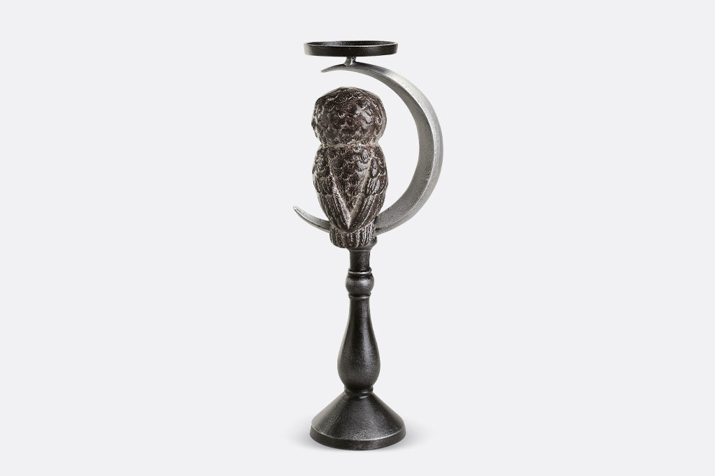 Decorative candle holder with owl design on a white background