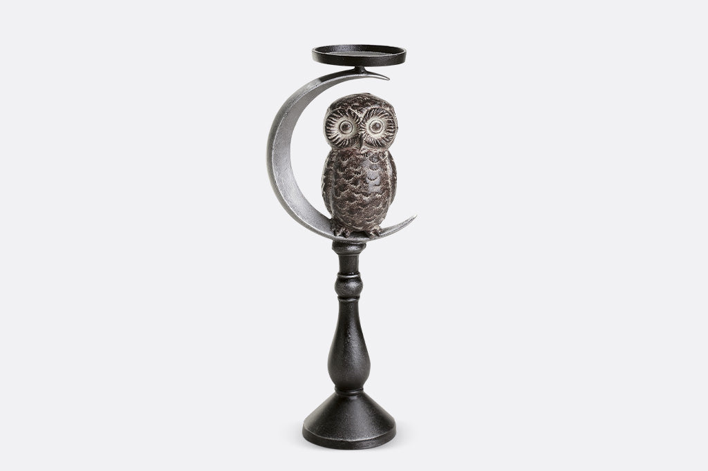 Decorative candle holder with owl design on a white background