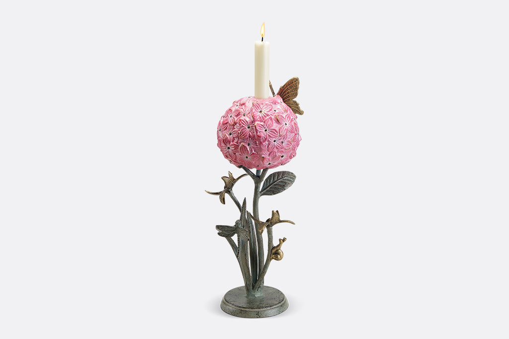 A single taper candleholder of a hydrangea blossom surrounded by a butterfly, dragonfly, and a snail.