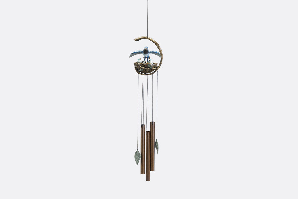A windchime sculpture featuring a mama blue bird watching over her babies in their nest.