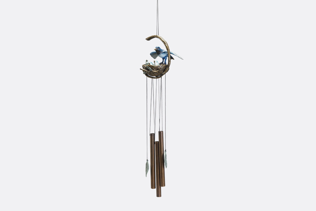 A windchime sculpture featuring a mama blue bird watching over her babies in their nest.