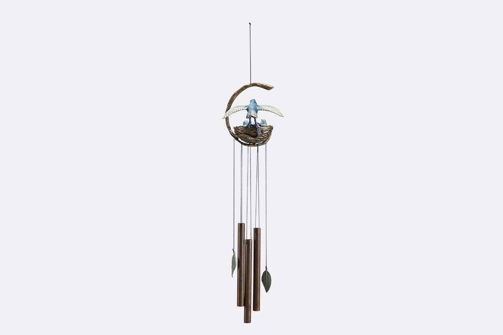 A windchime sculpture featuring a mama blue bird watching over her babies in their nest.