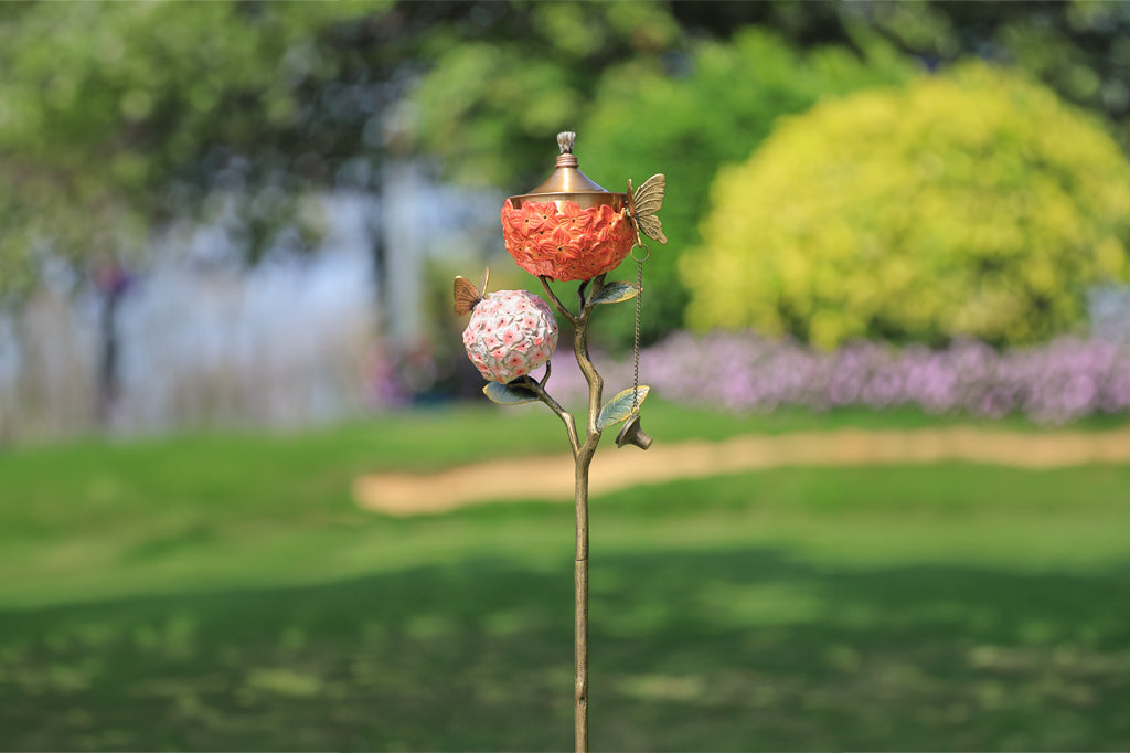 Decorative garden stake with floral design in a garden setting