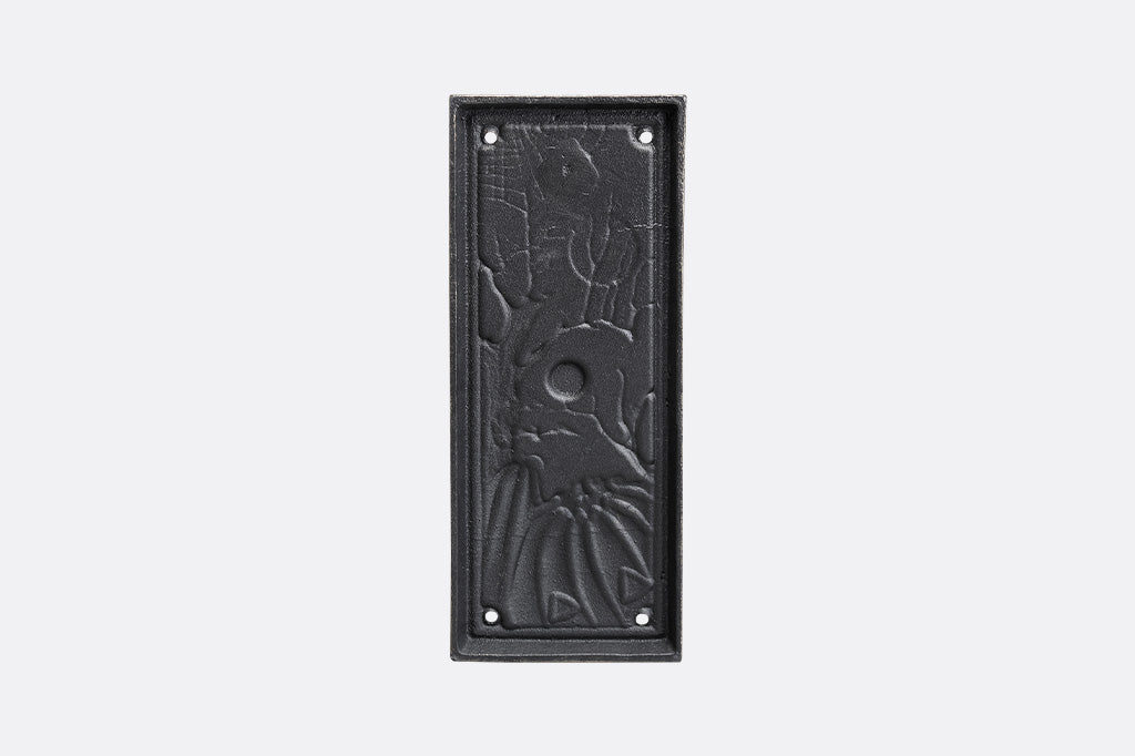 Decorative black metal plate with embossed design on a white background