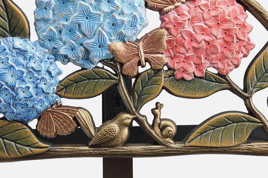 Decorative garden hose close up detailing flowers, birds, and a snail on a white background